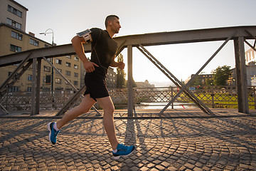 Image showing man jogging across the bridge at sunny morning