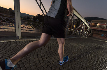 Image showing man jogging across the bridge in the city