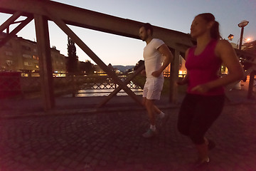 Image showing couple jogging across the bridge in the city