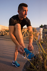 Image showing man tying running shoes laces