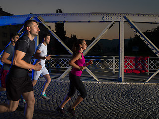 Image showing young people jogging across the bridge