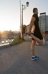 Image showing athlete man warming up and stretching