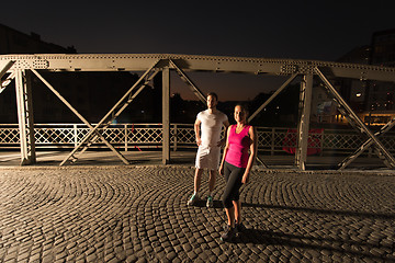 Image showing couple jogging across the bridge in the city