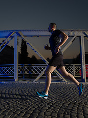 Image showing man jogging across the bridge in the city