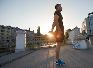 Image showing athlete man warming up and stretching