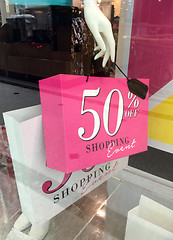 Image showing Boutique mannequin holding sale sign on shopping bag