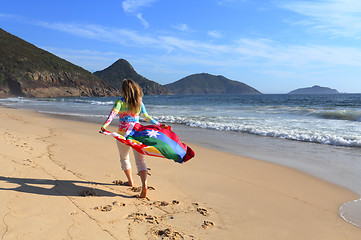 Image showing Woman runs along the beach with an Australian Flag