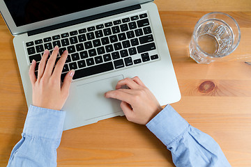 Image showing Top view of woman typing on laptop computer