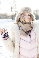 Image showing young pretty teenage hipster girl outdoor in winter snow park having fun drinking coffee, warming up happy smiling, lifestyle people concept