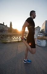 Image showing athlete man warming up and stretching