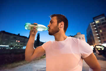 Image showing man drinking water after running session