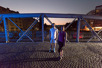 Image showing couple jogging across the bridge in the city