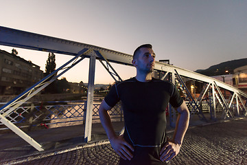 Image showing man jogging across the bridge in the city