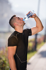 Image showing man drinking water from a bottle after jogging