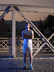 Image showing man jogging across the bridge in the city