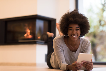 Image showing black women using tablet computer on the floor