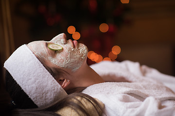 Image showing woman is getting facial clay mask at spa