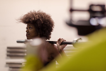 Image showing black woman lifting empty bar