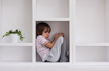 Image showing young boy posing on a shelf