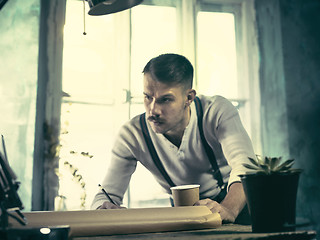 Image showing Architect working on drawing table in office