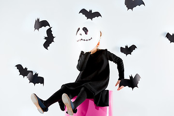 Image showing Little girl witch in black dress over magical accessories. Halloween, the studio evening.