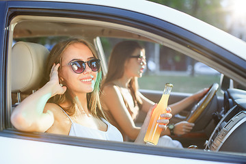 Image showing The young women in the car smiling