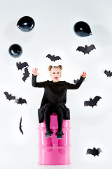 Image showing Little girl witch in black dress over magical accessories. Halloween, the studio evening.