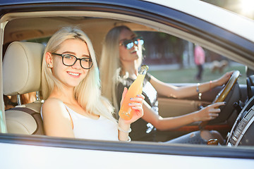 Image showing The young women in the car smiling