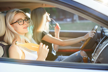 Image showing The young women in the car smiling