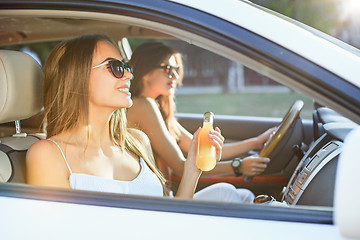 Image showing The young women in the car smiling