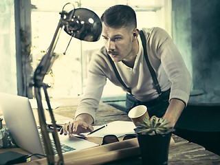 Image showing Architect working on drawing table in office