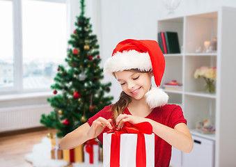 Image showing smiling girl in santa hat with christmas gift