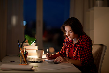 Image showing student girl with notebook and calculator at home