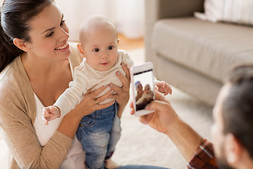 Image showing happy family with baby photographing at home