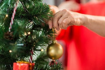 Image showing close up of senior woman decorating christmas tree