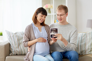 Image showing happy couple with ultrasound images at home