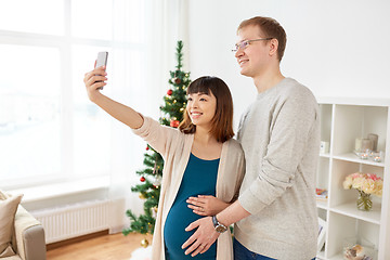 Image showing happy family couple taking selfie at christmas