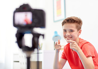 Image showing happy boy with camera recording video at home