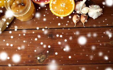 Image showing honey, citrus fruits, ginger and garlic on wood