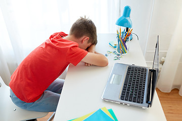 Image showing tired or sad student boy with laptop at home