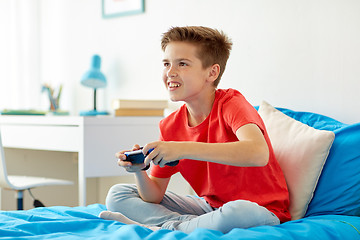 Image showing happy boy with gamepad playing video game at home