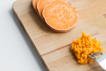 Image showing hand with fork making mashed batata on board