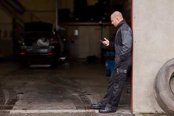 Image showing auto mechanic with smartphone at car service