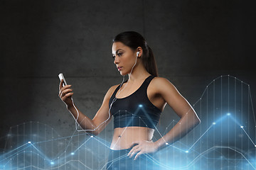 Image showing woman with smartphone and earphones in gym