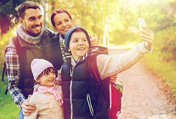 Image showing family with backpacks taking selfie by smartphone