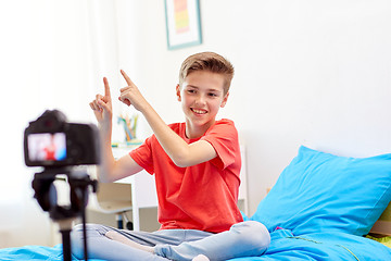 Image showing happy boy with camera recording video at home