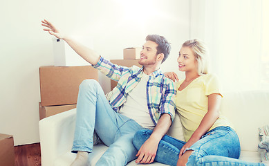 Image showing couple with boxes moving to new home and dreaming