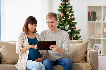 Image showing man and pregnant wife with tablet pc at christmas