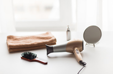 Image showing hairdryer, hair brushes, mirror and towel