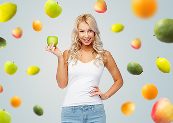 Image showing happy beautiful young woman with green apple